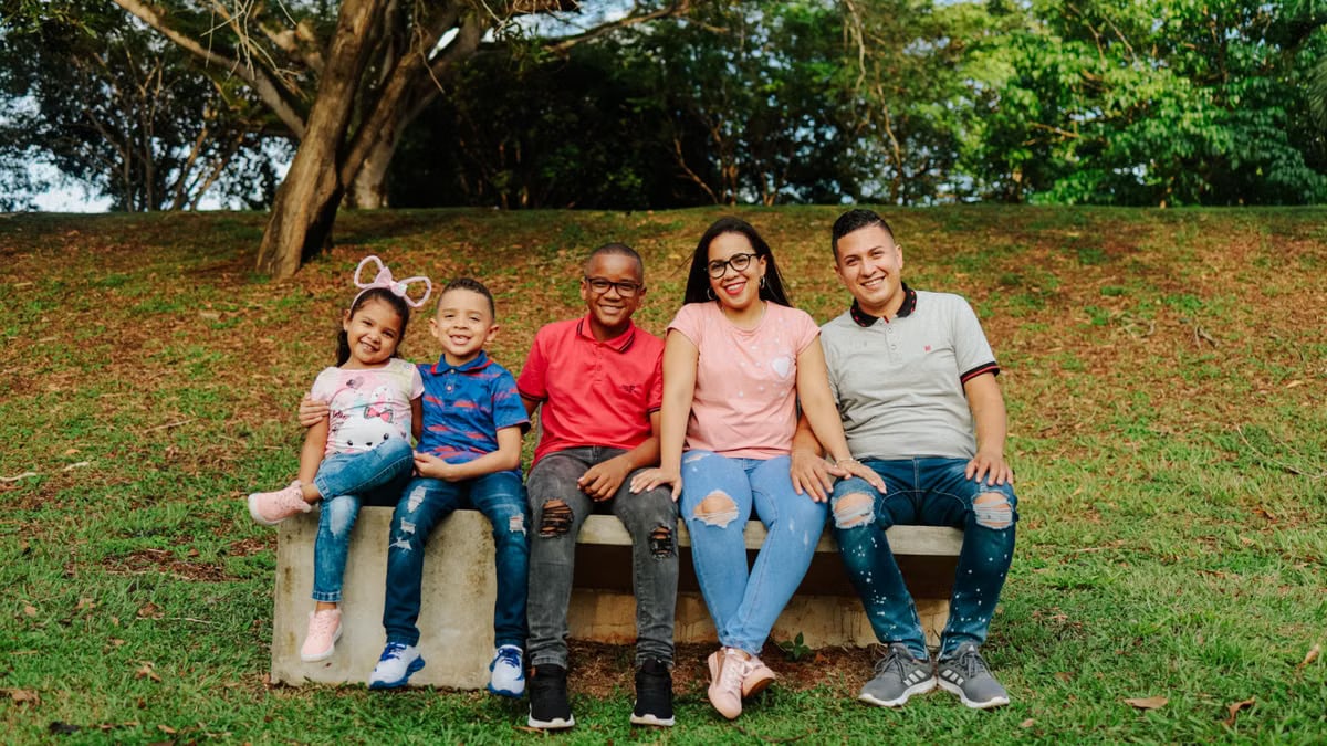 Joyful family enjoying outdoor time on a park bench with smiles and love.